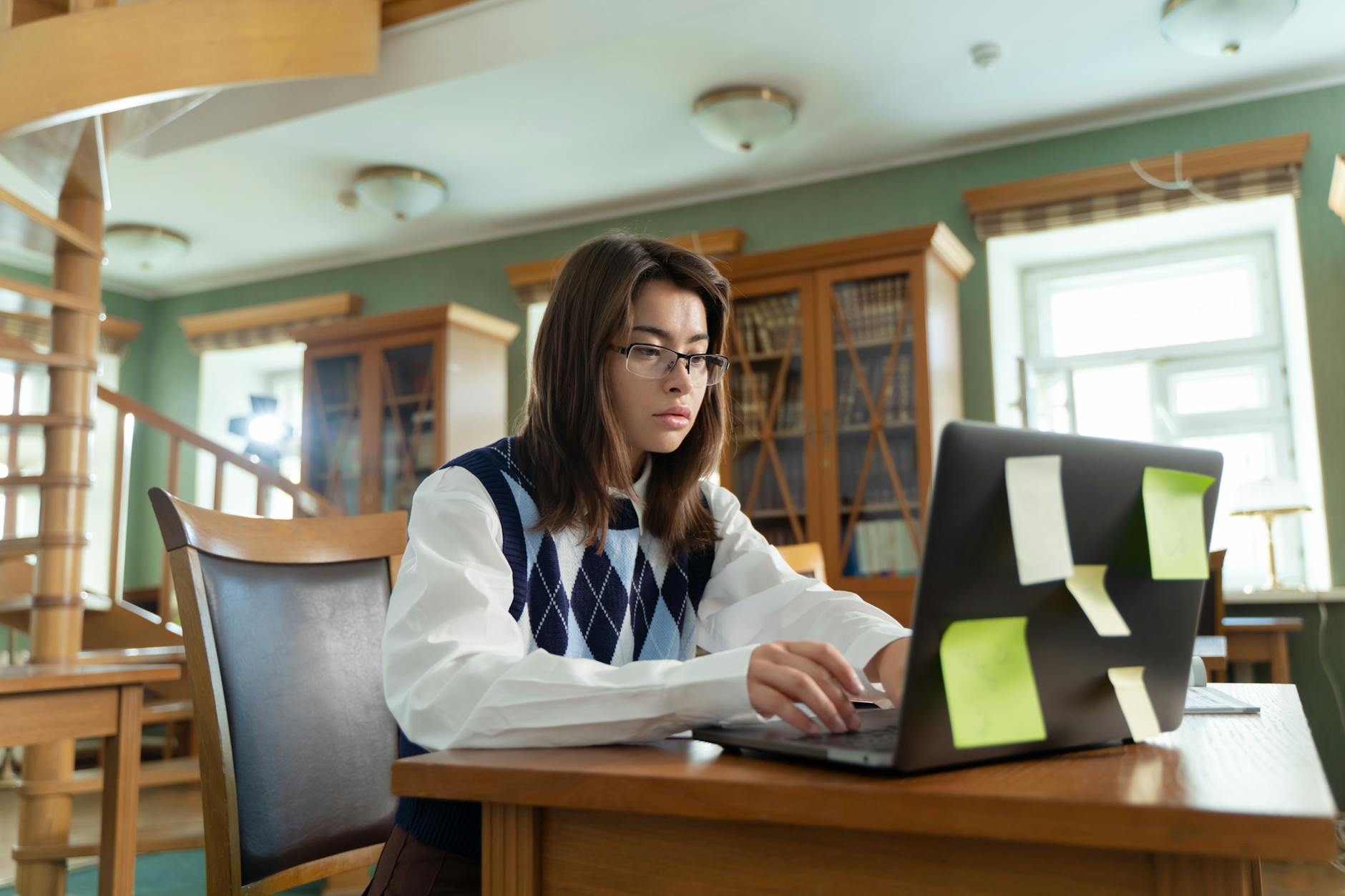 a schoolgirl typing on a laptop