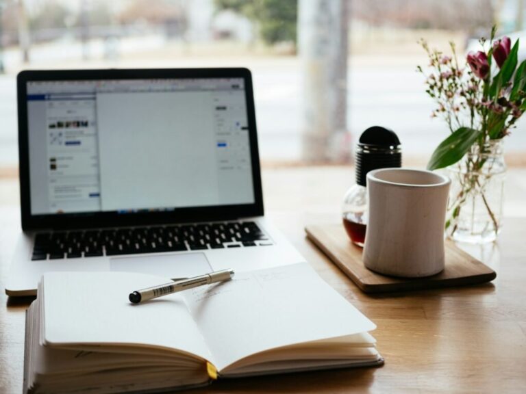 Student's desk setup with laptop and notebook for writing a professional email to a professor